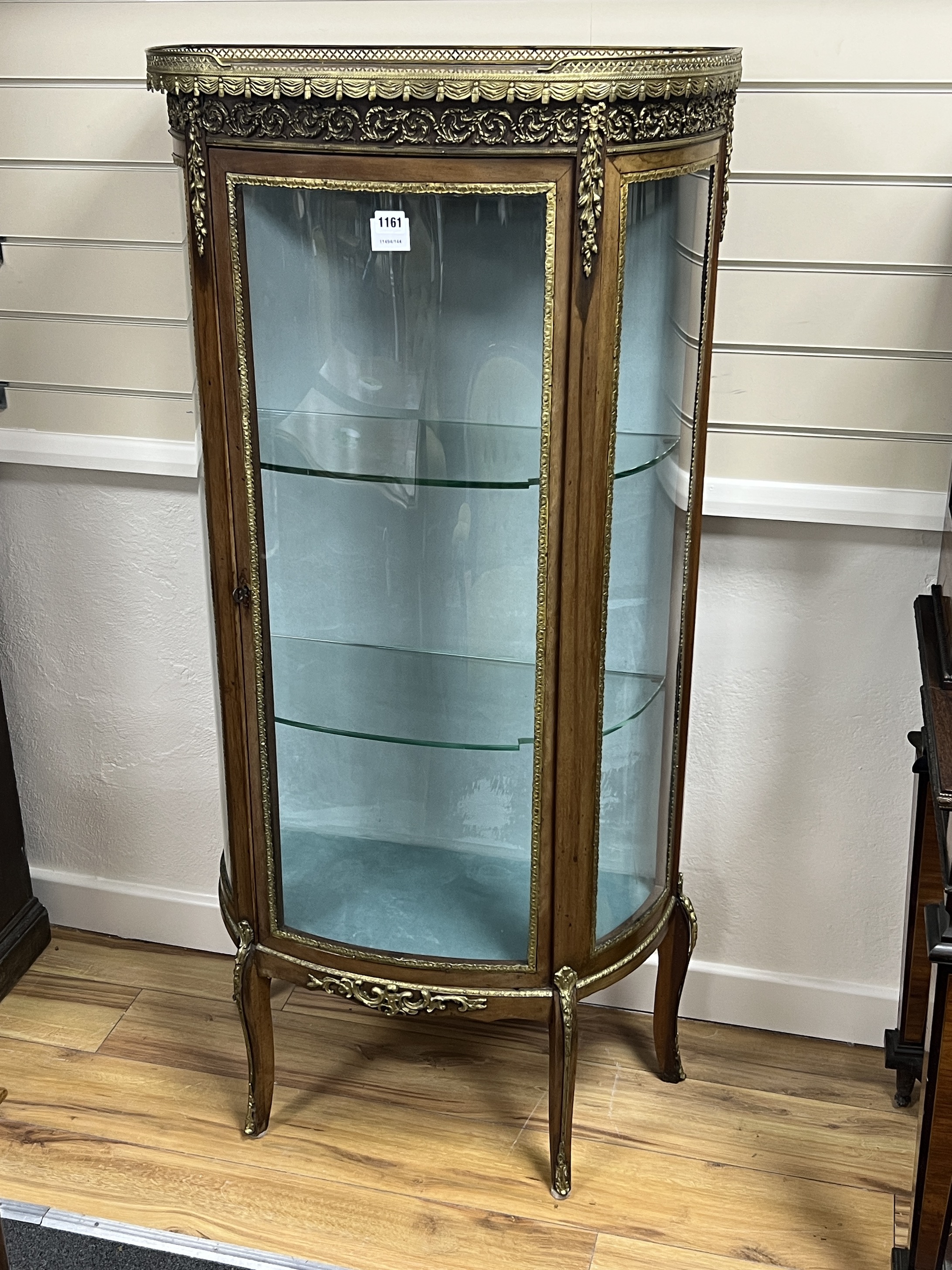 A French gilt metal mounted marble topped bow front vitrine, width 66cm, depth 32cm, height 140cm